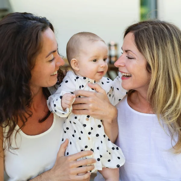 Dos madres compartiendo a su bebé